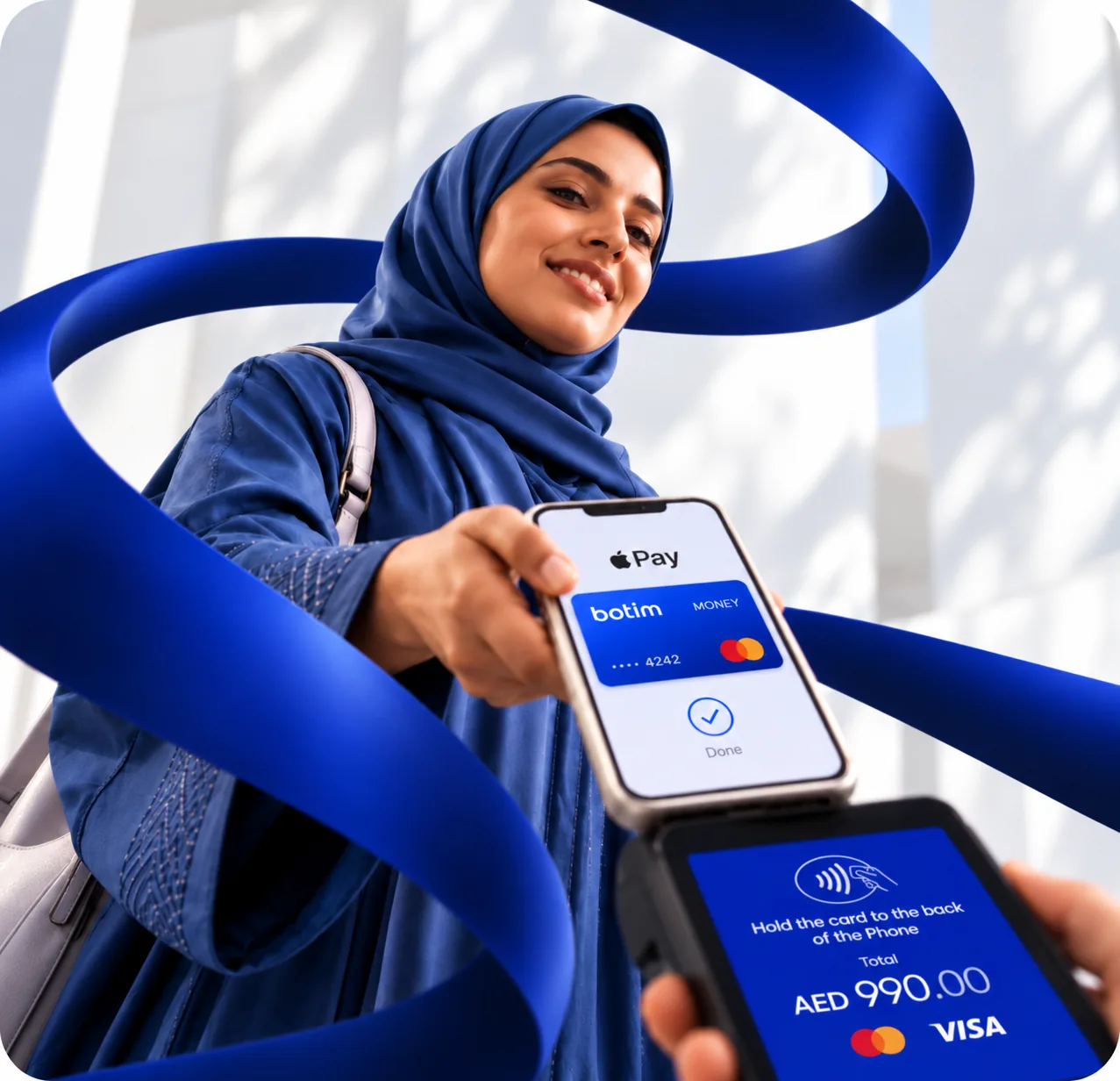 Smiling woman in a blue hijab paying with her phone at a card terminal